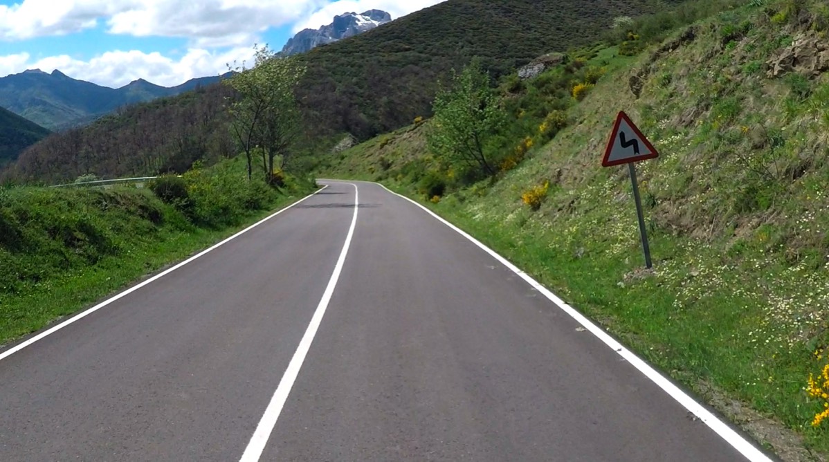road sign showing corners on smooth road surface