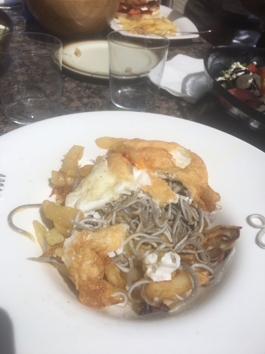 Plate of Spanish food fried eggs sea snakes eels on chips with garlic oil